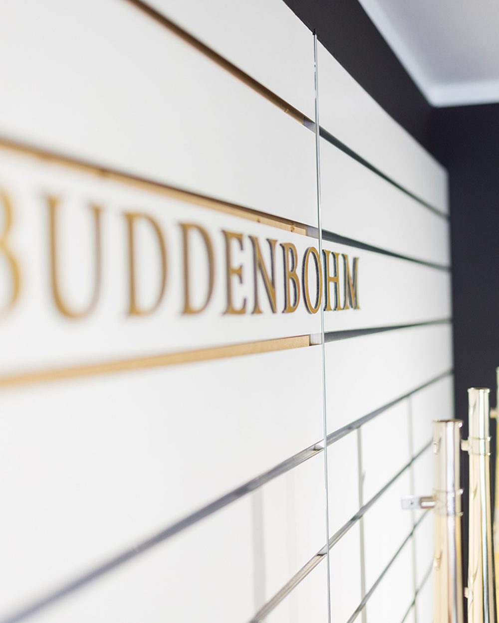 BUDDENBOHM Schriftzug in Gold an der Showroom-Wand